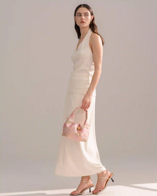 Silkyhaus pink brocade hobo bag with gold hardware, side full-body view of model in neutral outfit
