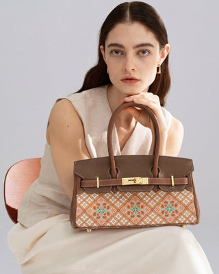 Caisson pattern brocade leather handbag, stylish female model front view
