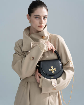Black Leather Crown Handbag shown in a front view on a model, genuine leather crown handbag by Silkyhaus.