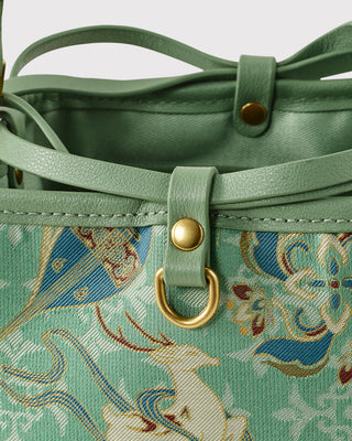Close-up of nine-colored deer motif and hardware on green brocade bag